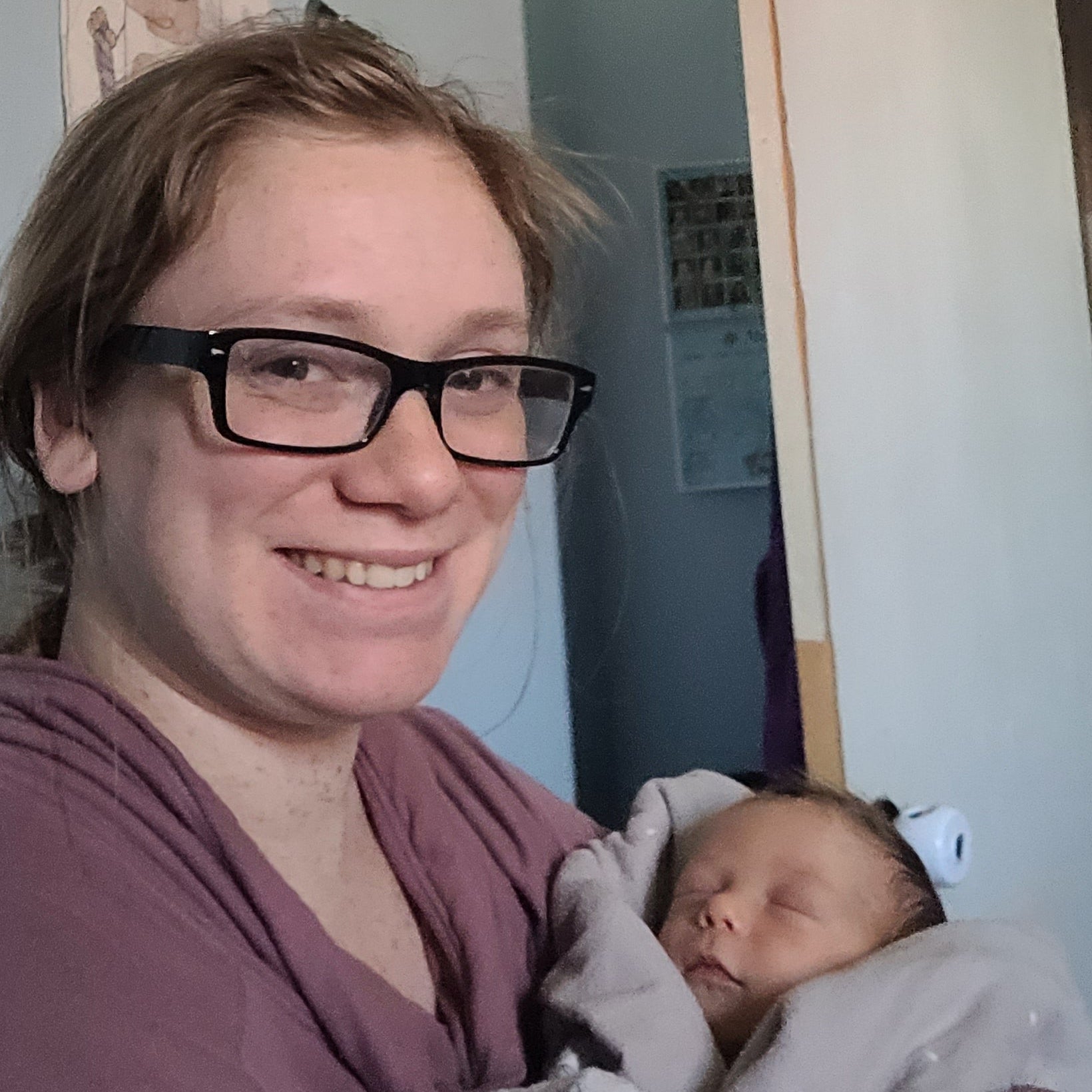 Person holding a baby with a neutral background