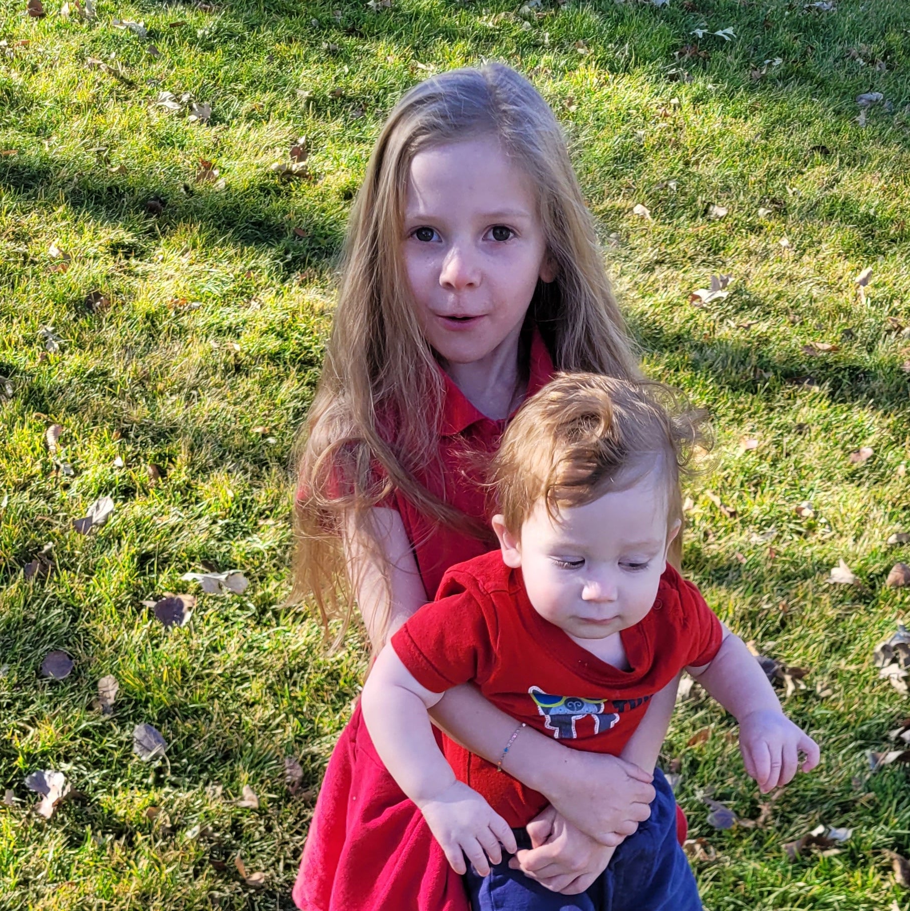 Two children standing on grass, viewed from above