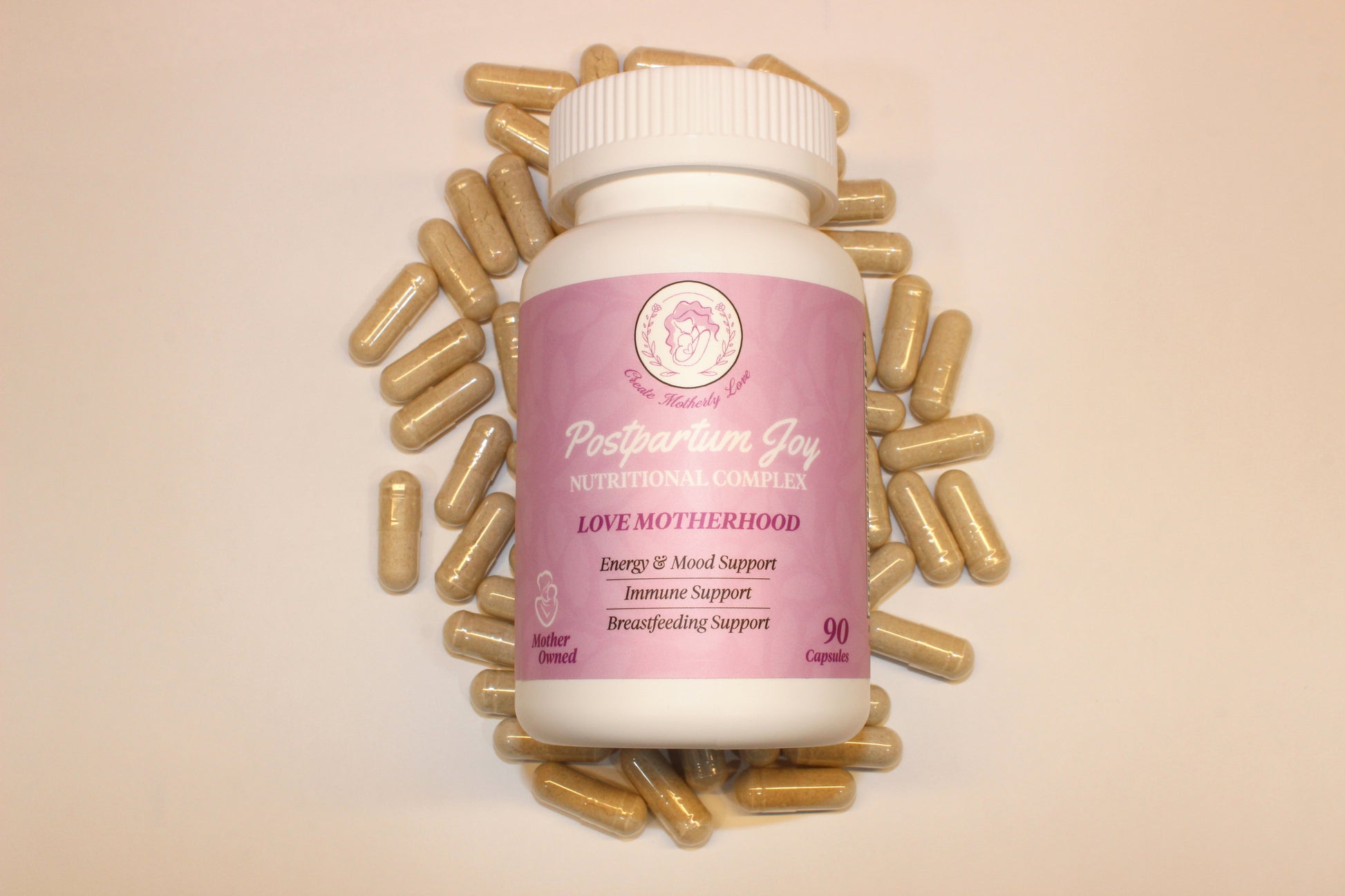 Supplement bottle labeled 'Postpartum Joy' surrounded by gold capsules on a beige background