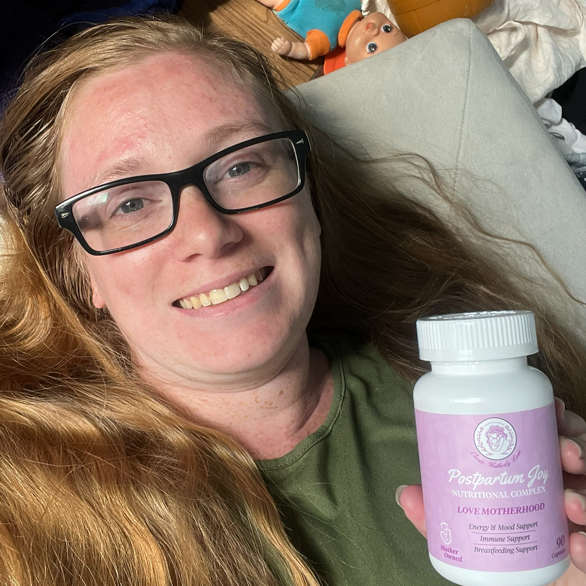 Person holding a bottle of 'Perpetual Joy' supplement with a casual background